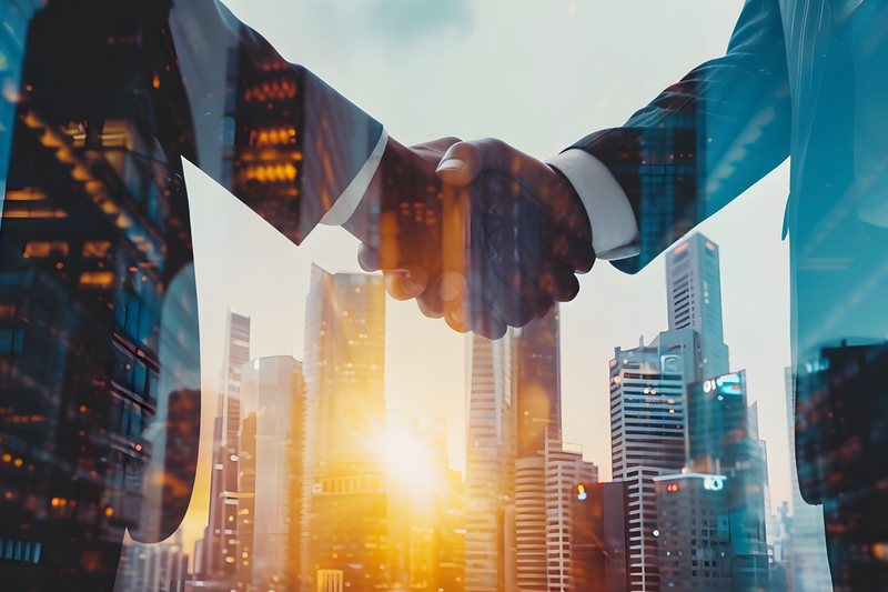Two people shaking hands, superimposed over a sunlit city skyline.
